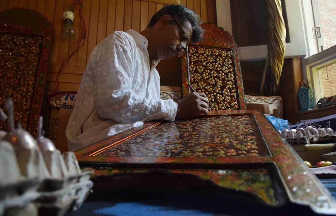 66 years old Mirza is engrossed in his work on a paper mache decorative wall plaque (1) Photo Essay: A World in Colours – Six Decades of Naqashi Mastery